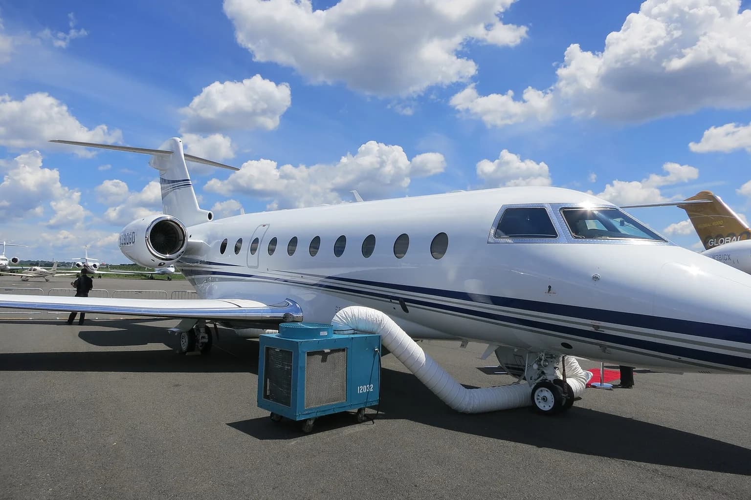 Gulfstream G280 business jet on an exhibition apron beneath blue skies.